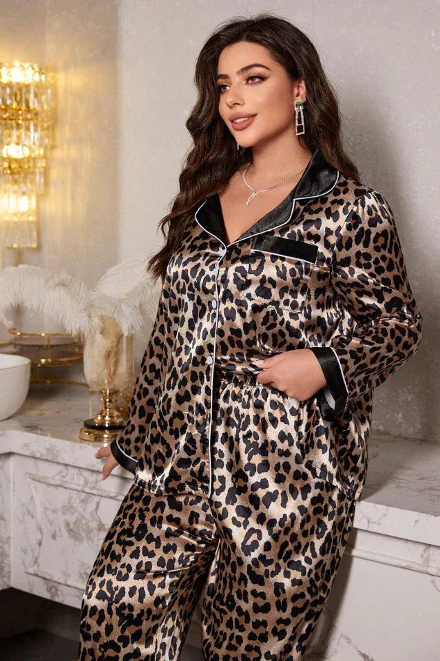 Woman in a leopard print satin pajama set with contrasting piping, looking towards the camera.