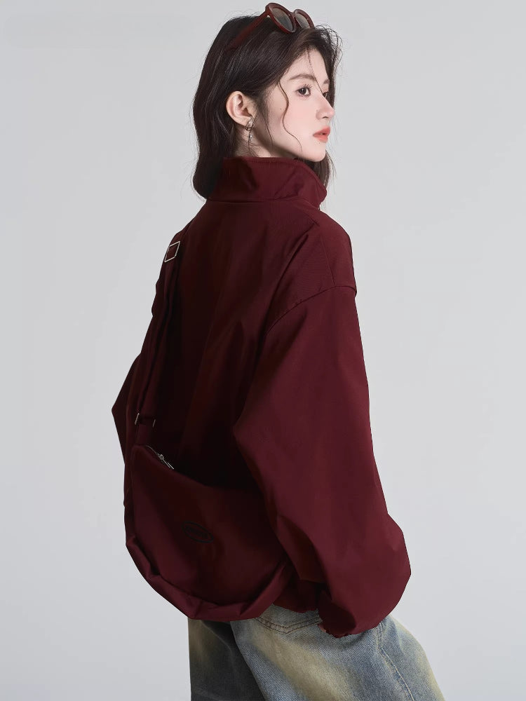 Rear view of a woman in a maroon bomber jacket with a wide collar and full sleeves