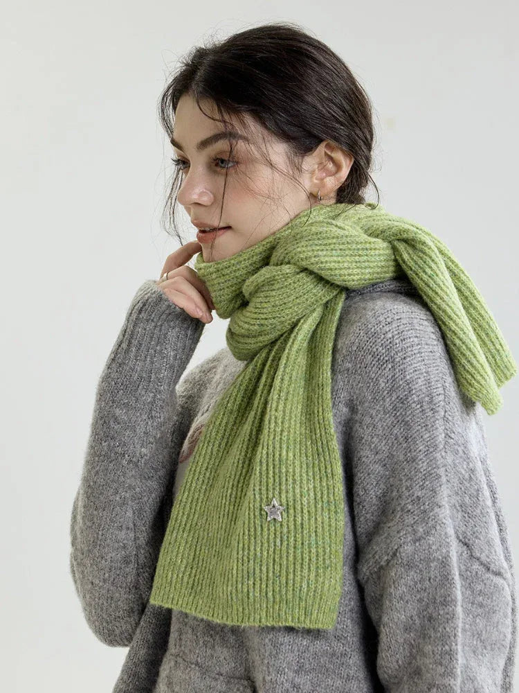Close-up of a woman wearing a light green ribbed knit scarf.