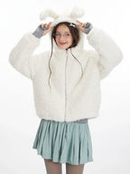 Woman playfully posing with the bunny ears on the hood of her white fuzzy fleece jacket.