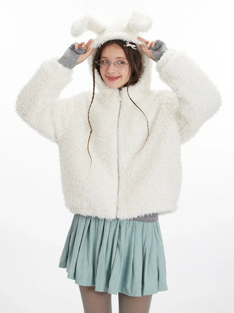 Woman playfully posing with the bunny ears on the hood of her white fuzzy fleece jacket.