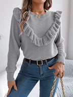 Woman wearing a gray ruffle trim knit sweater