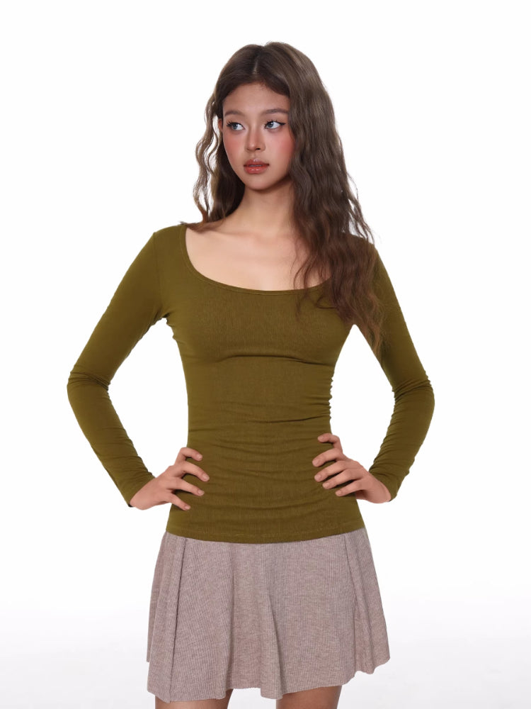 Woman wearing a fitted, long-sleeve olive green ribbed top with a scoop neckline.