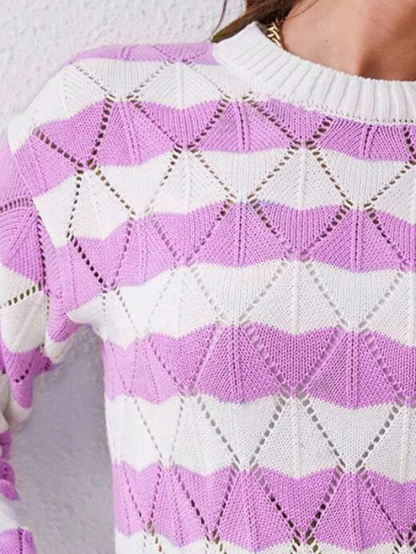 Detail of the shoulder and neckline of a geometric knit sweater.