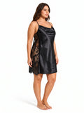 Woman wearing a black satin slip dress with lace insets from a three-quarter side view.