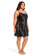 Woman wearing a black satin slip dress with lace insets from a three-quarter side view.
