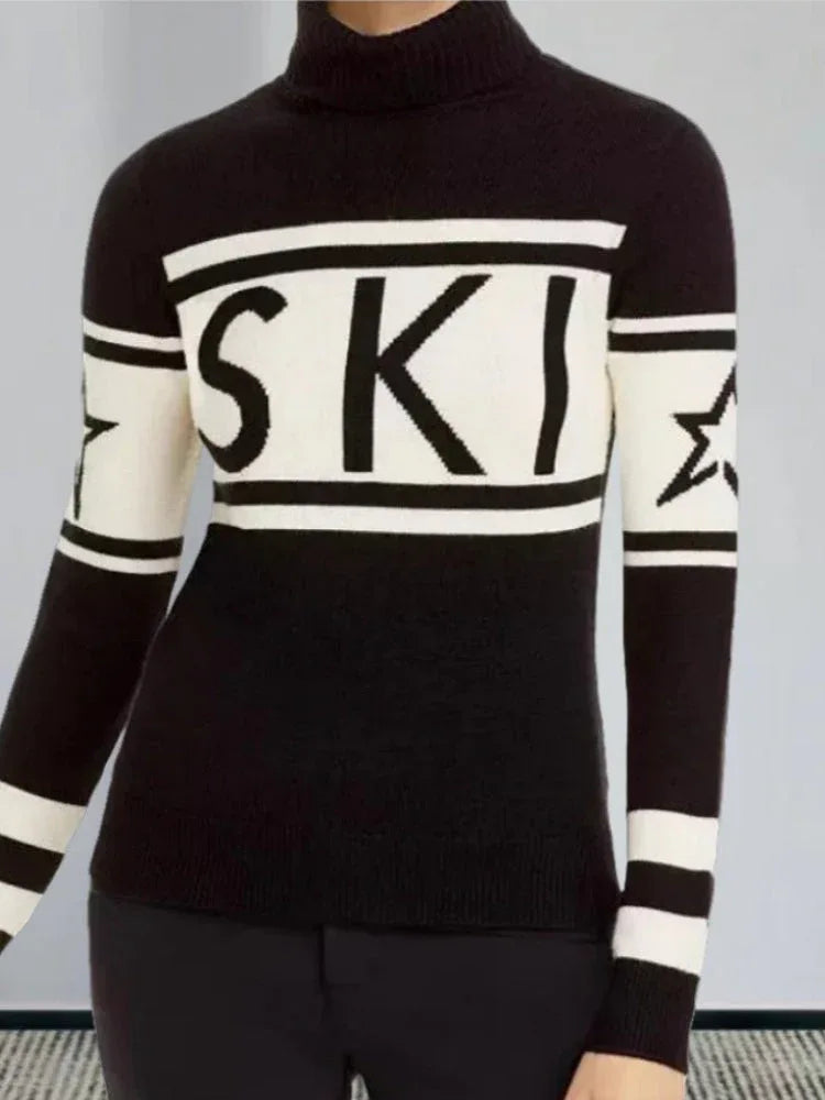 Woman in a black and white knit turtleneck sweater with 'SKI' graphic and striped sleeves