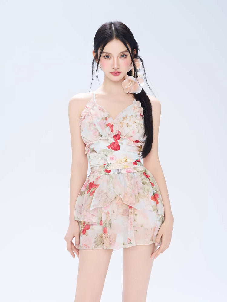 Front view of a woman in a floral print tiered dress with spaghetti straps.