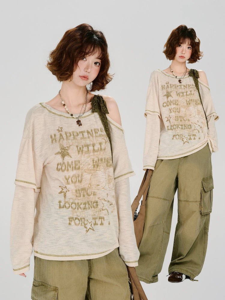 Model posing in a cream-colored long-sleeved graphic t-shirt and olive green cargo pants.