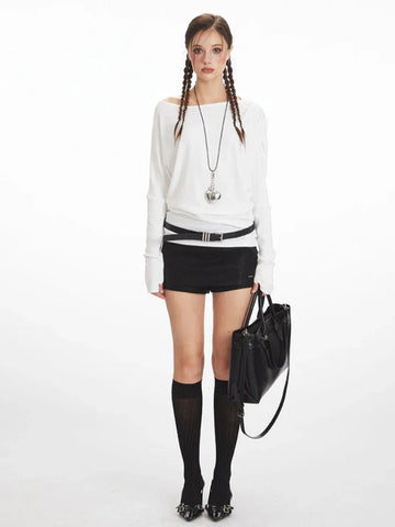 Model wearing a white long-sleeve top with a boat neckline and black shorts.
