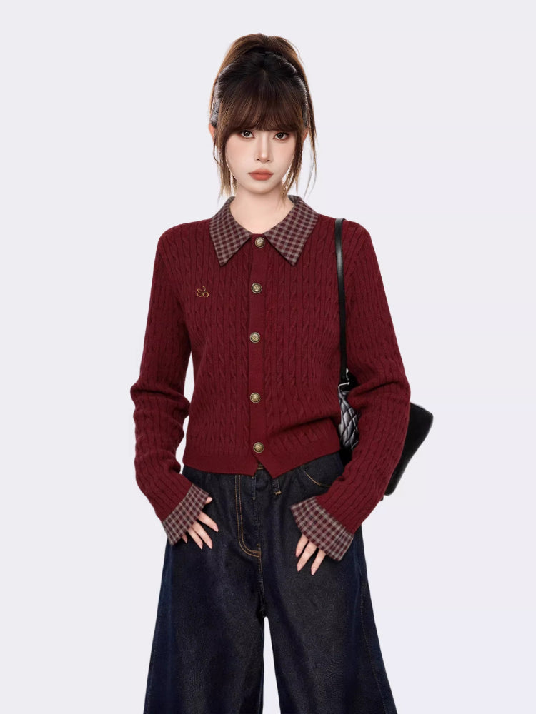 Woman wearing a burgundy cable knit cardigan with a plaid collar and cuffs, paired with dark wash wide-leg jeans.