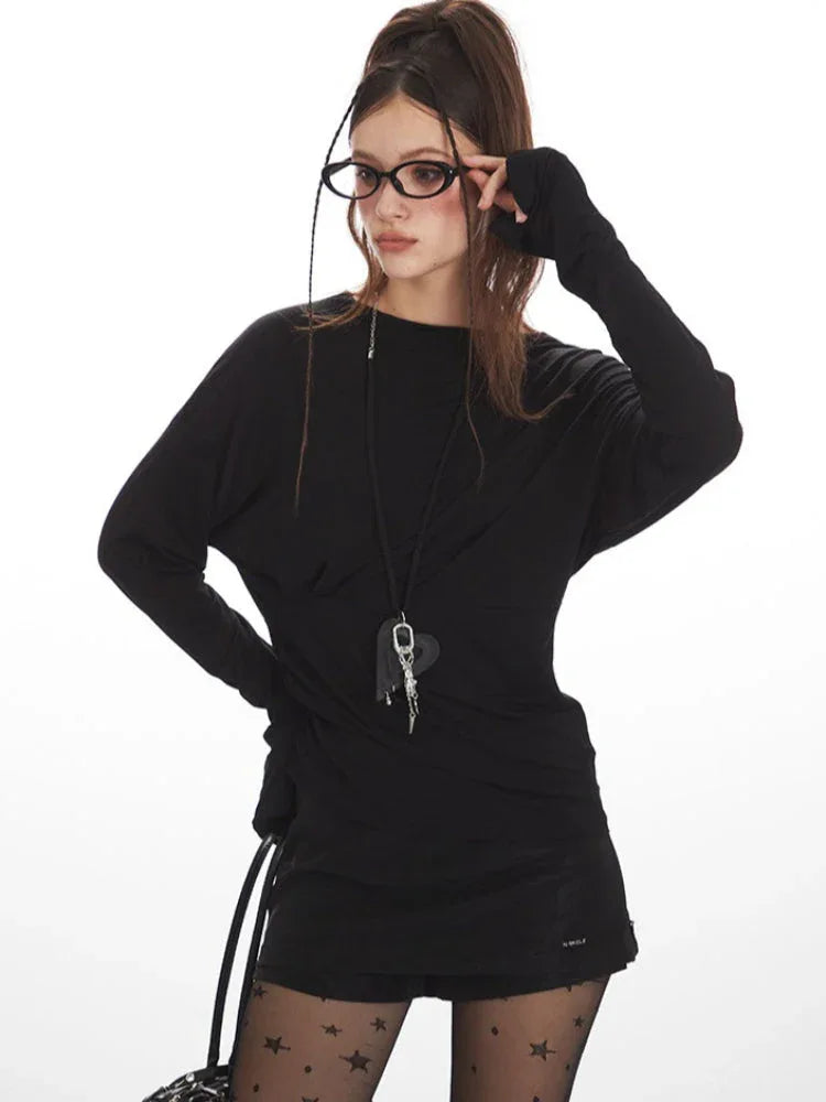 Close-up of the model's face and upper body, showcasing the black long-sleeved top and accessories.