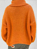 Rear view of a woman wearing an orange chunky knit turtleneck sweater.