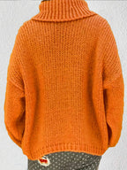 Rear view of a woman wearing an orange chunky knit turtleneck sweater.