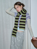 Model posing with a striped knit scarf
