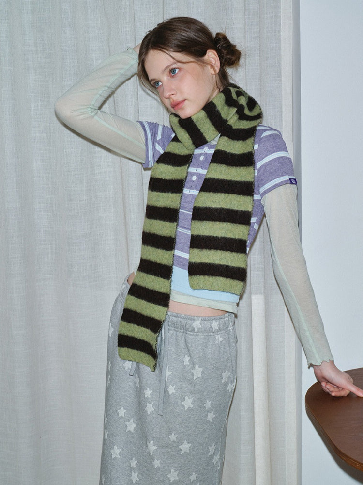 Model posing with a striped knit scarf