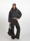Front view of a woman in a grey cropped puffer jacket with a zippered front and chest pocket.