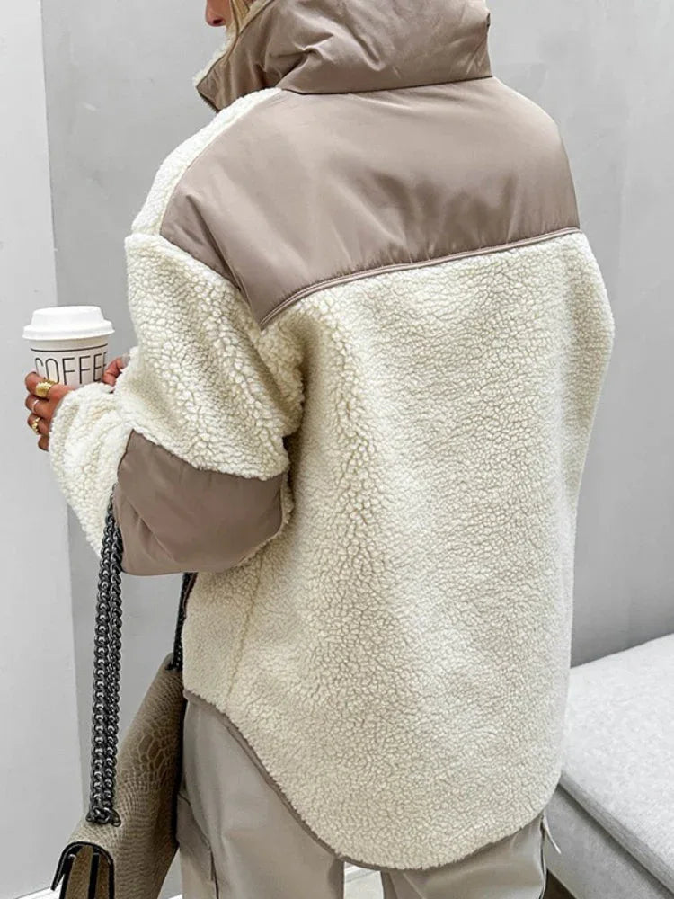 Back view of a woman wearing a cream sherpa fleece quarter-zip pullover with contrast brown panels on the shoulders and sleeves.