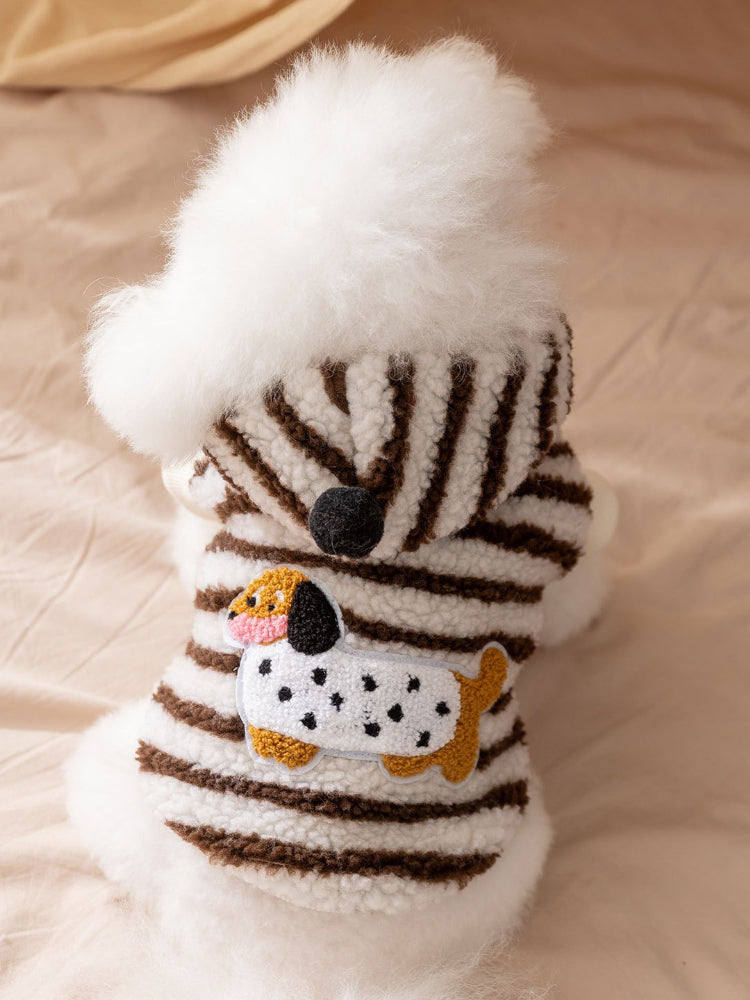 Dog wearing a brown and white striped hooded dog coat with a Dalmatian appliqué.