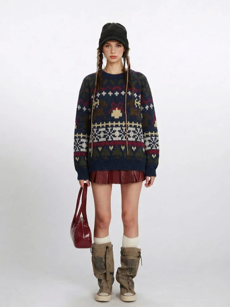 Woman wearing a navy blue knit sweater with a Fair Isle pattern featuring reindeer and snowflake motifs, paired with a red mini skirt and beige boots. Main image