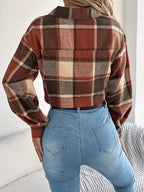 Back view of a woman wearing a plaid cropped shirt jacket and blue jeans