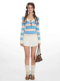 Woman wearing a blue and white striped long-sleeve knit sweater with a v-neckline.