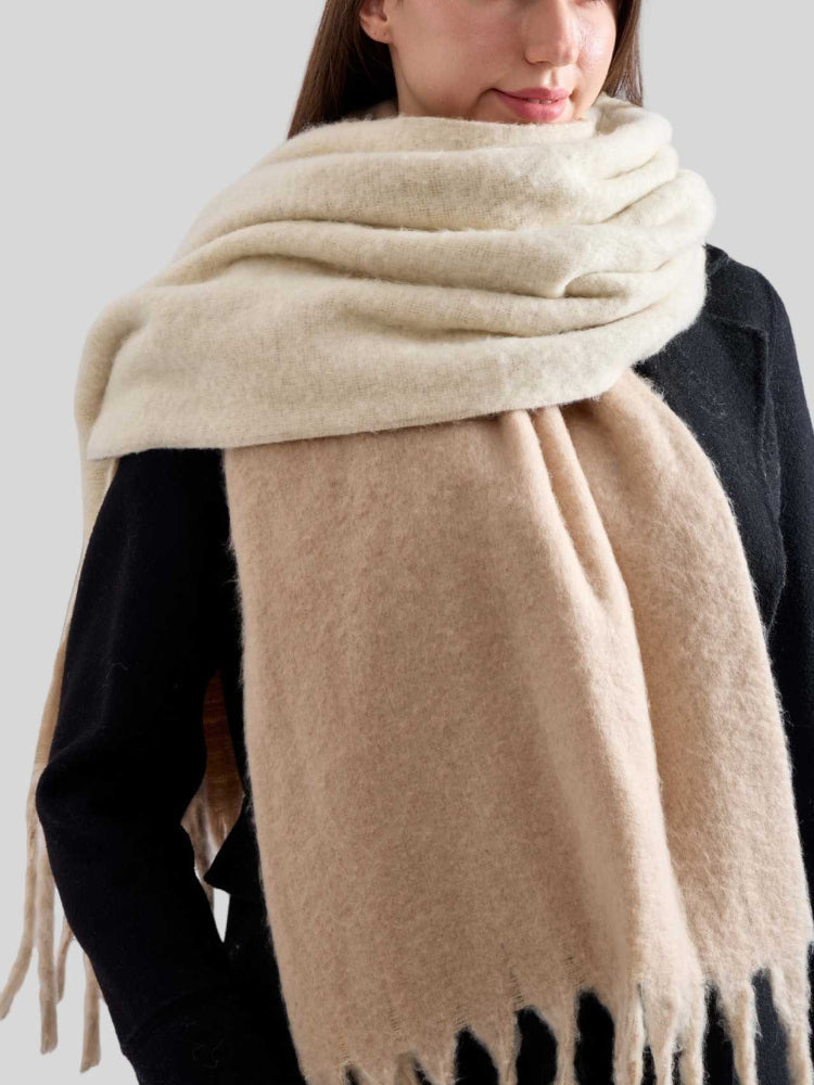 Detail shot of the textured fabric and fringe on a beige scarf