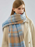 close-up of a woman wearing a blue and tan plaid scarf