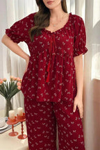 Front view of a woman in a red patterned pajama set with short puff sleeves.