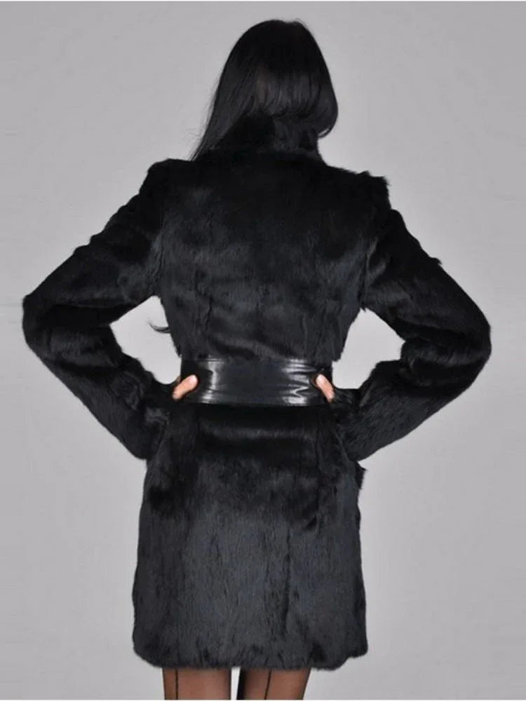 Woman wearing a black faux fur coat with a black leather belt, back view