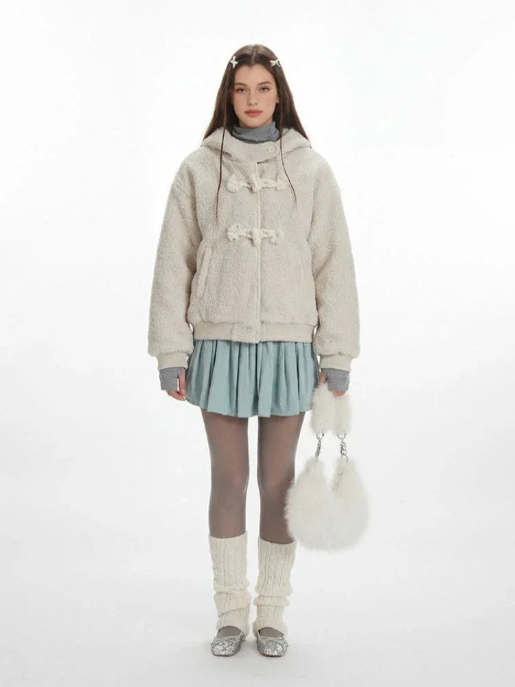 Woman wearing a cream fleece toggle coat with a hood. Main image
