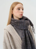 Model showcasing the drape and texture of a classic tartan scarf.