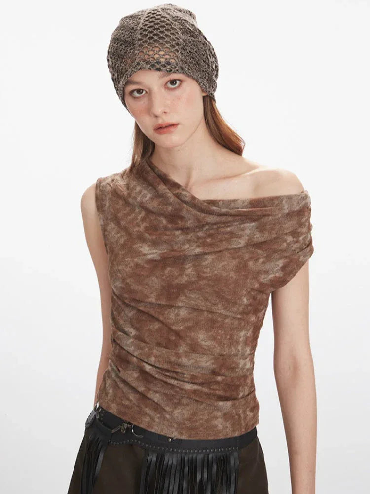 Front view of a model showcasing the brown textured knit top with asymmetrical neckline and draping detail.