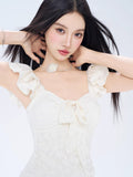 Close-up of the neckline and ruffled sleeves of a white jacquard mini dress.