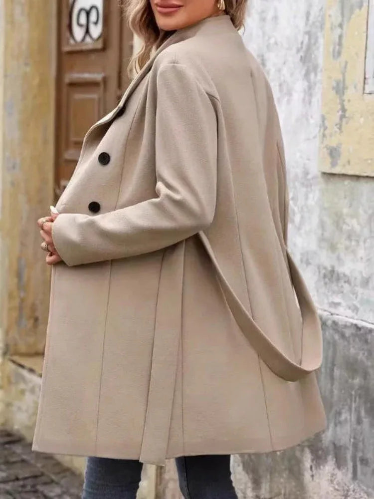 Back view of a beige wool blend coat with belted waist and button details