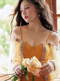 Close-up of a woman in a mustard yellow swimsuit featuring sweetheart neckline and sheer sleeves