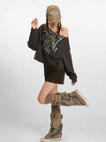 Woman posing in a dark grey distressed graphic print cropped sweatshirt with an off-the-shoulder neckline, dark brown mini skirt, and styled socks and boots.