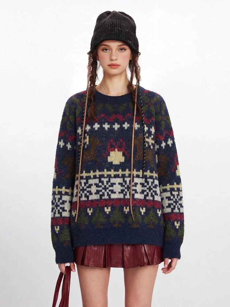 Front view of a woman in a navy blue knit sweater with a Fair Isle pattern, red mini skirt, and black beanie.