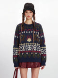 Front view of a woman in a navy blue knit sweater with a Fair Isle pattern, red mini skirt, and black beanie.