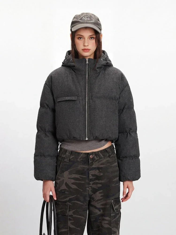 Close-up of the grey textured fabric of the cropped puffer jacket.