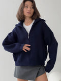 Detail shot of the zipper and collar on a navy blue knit jacket.