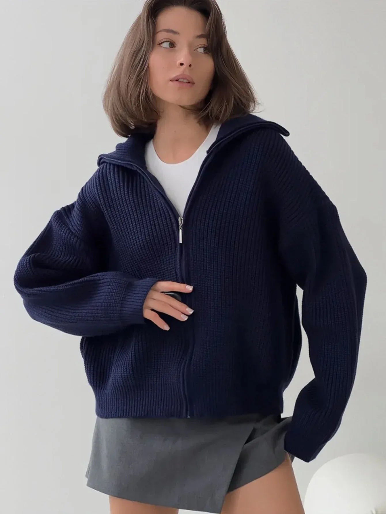 Detail shot of the zipper and collar on a navy blue knit jacket.