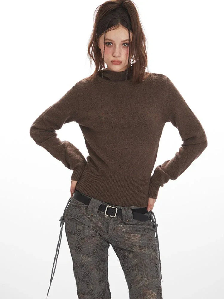 Woman posing in a brown turtleneck sweater and patterned pants