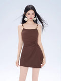Front view of a woman in a brown ribbed knit mini dress with a knot detail and spaghetti straps.