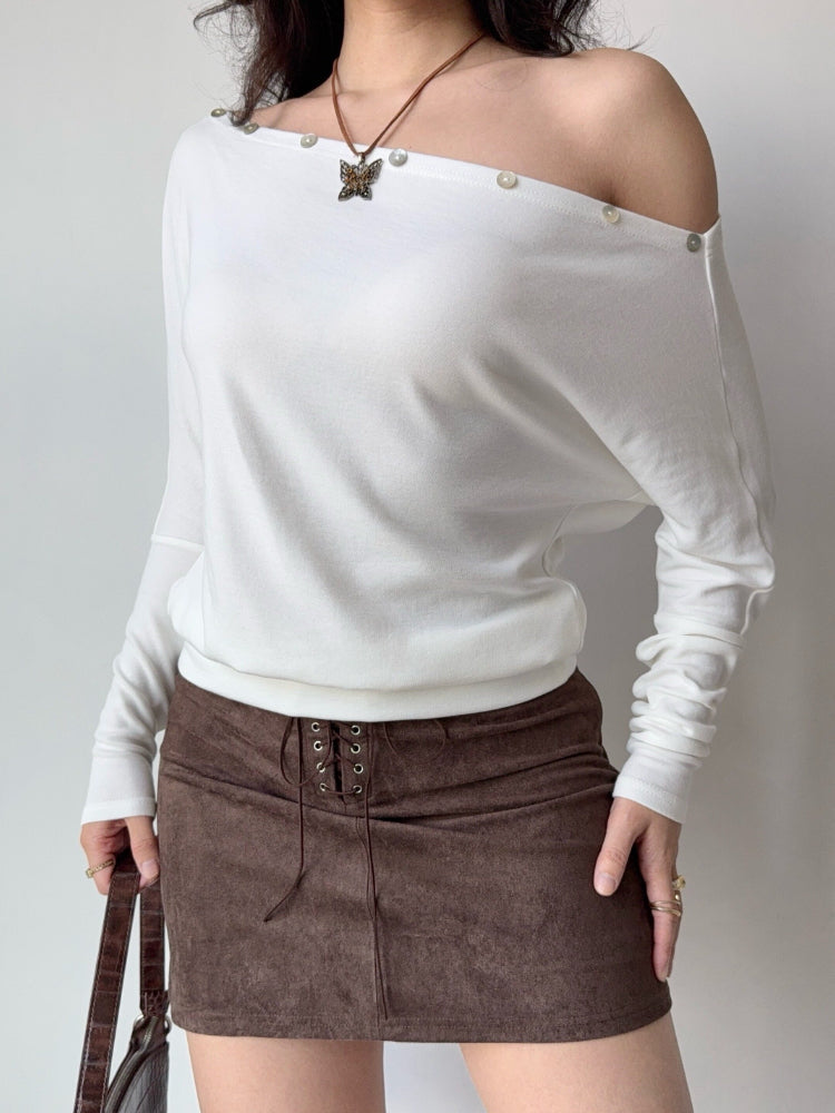 Full body shot of a model in a white off-the-shoulder top and brown skirt.