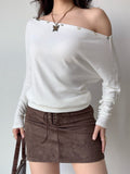 Full body shot of a model in a white off-the-shoulder top and brown skirt.