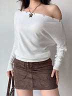 Full body shot of a model in a white off-the-shoulder top and brown skirt.