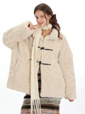 Close-up of a woman wearing a cream fleece toggle coat