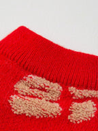 Close-up of the ribbed crew neck of a red knit dog sweater with Chinese characters