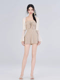 Full body shot of a woman in a striped fit and flare dress and sheer overlay cardigan.